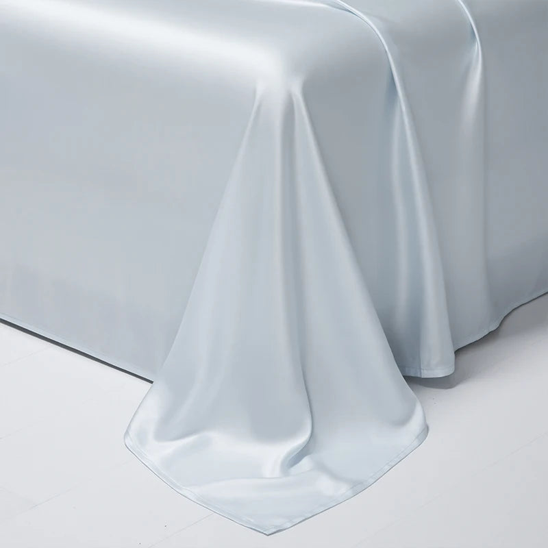 A smooth, light blue satin bed sheet draped elegantly on a white surface.