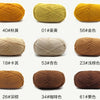 A collection of knitted yarn skeins in various shades of yellow, beige, and brown.