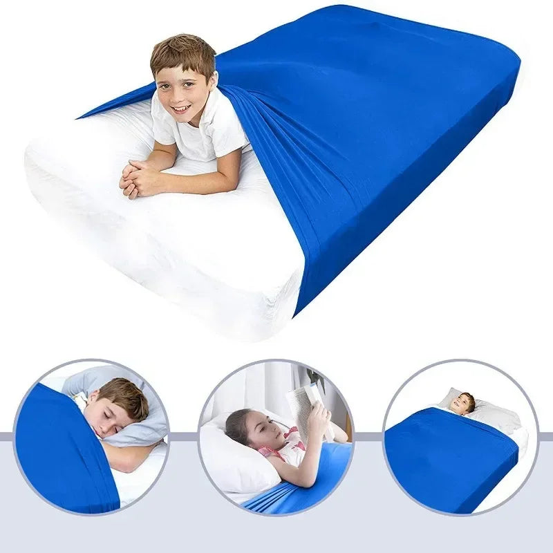 A boy lying on a blue breathable stretchy sensory bed sheet.