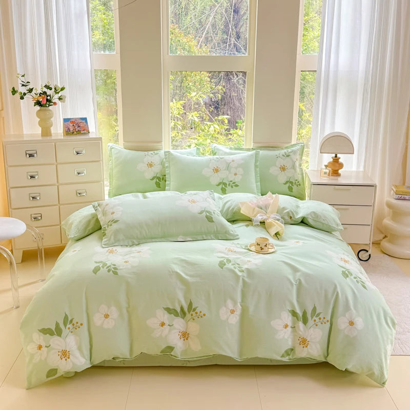 A light green cotton duvet cover and pillow set displayed on a bed with white curtains and natural light.