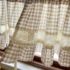 Beige gingham crochet lace curtain valance hanging in a window