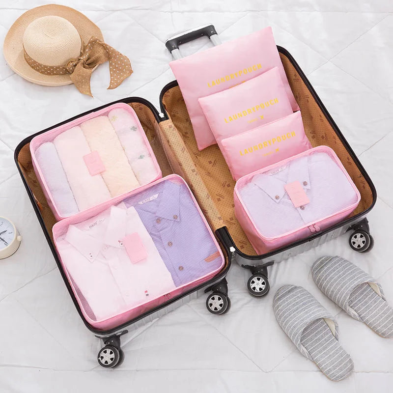 A storage organizer set featuring pink and lavender clothes and accessories in a wooden rolling case.