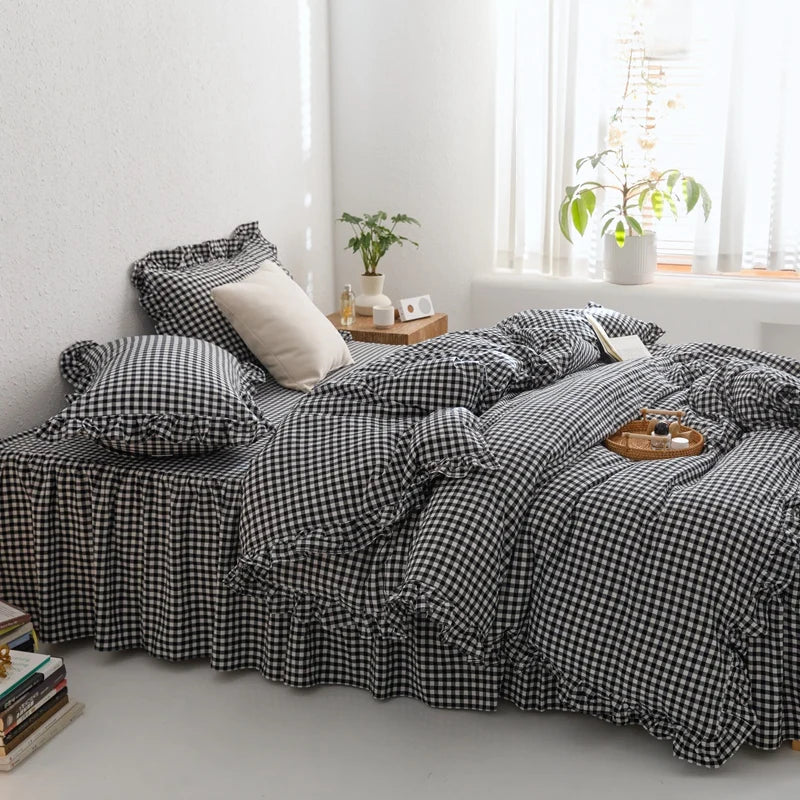 A black and white plaid duvet cover set displayed on a bed with natural light and greenery in the background.
