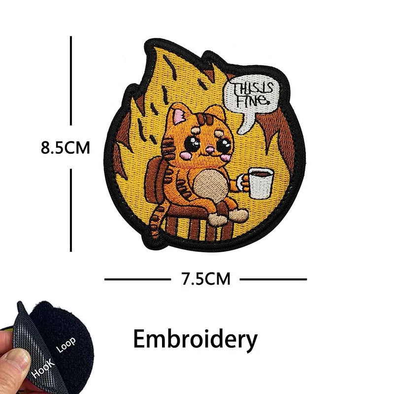An embroidered patch featuring an orange tabby cat looking thoughtful and holding a cup, with the text This is fine.