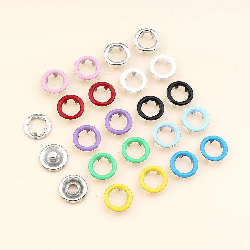 A collection of various colored precision button pliers, including rings and cutters, arranged in a radial pattern.