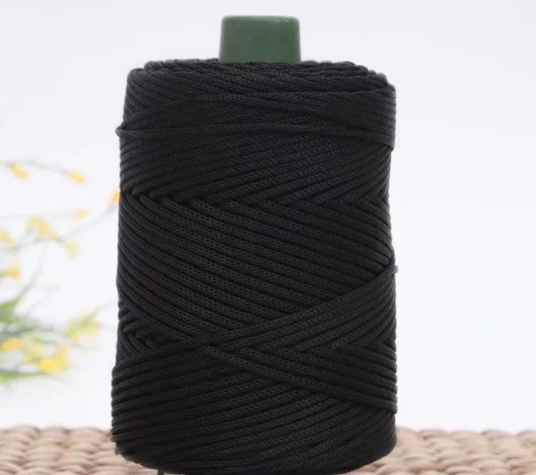 A spool of black crochet ice rope with a green cap, used for DIY crafts.