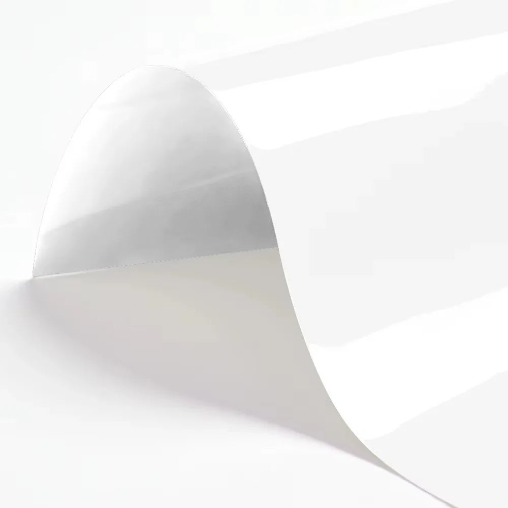 A sheet of white heat transfer vinyl is shown rolled or curved, highlighting its smooth surface.