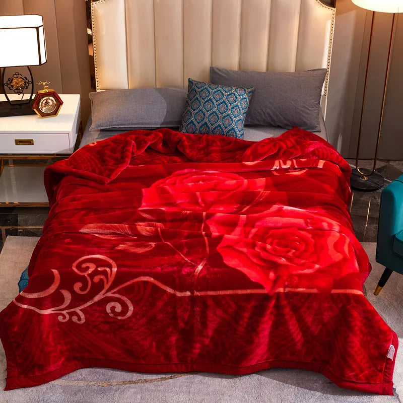 A vibrant red plush fleece blanket with a rose and peony floral pattern is displayed on a bed.
