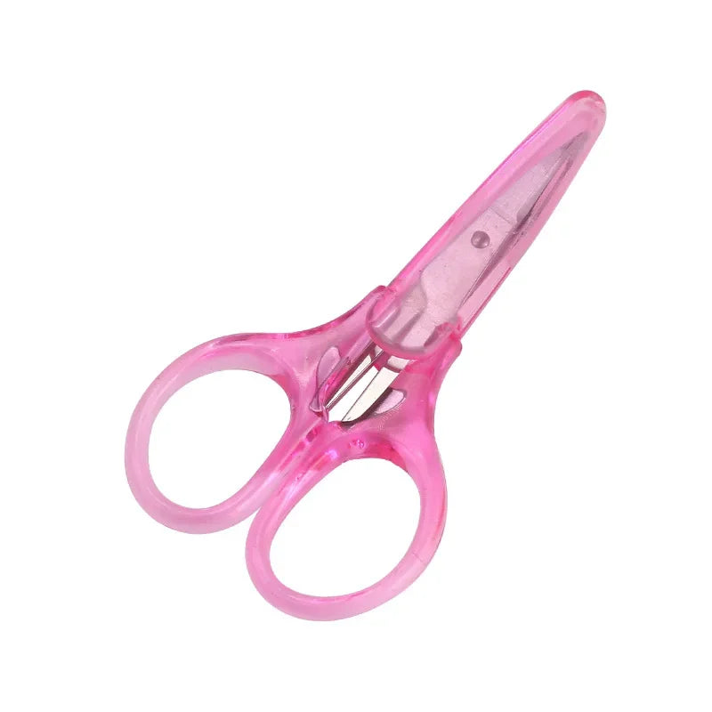 A pair of pink precision craft scissors with a protective cap shown against a white background.