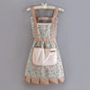 A floral pattern kitchen apron with adjustable straps and a pink pocket displayed on a wooden hanger.