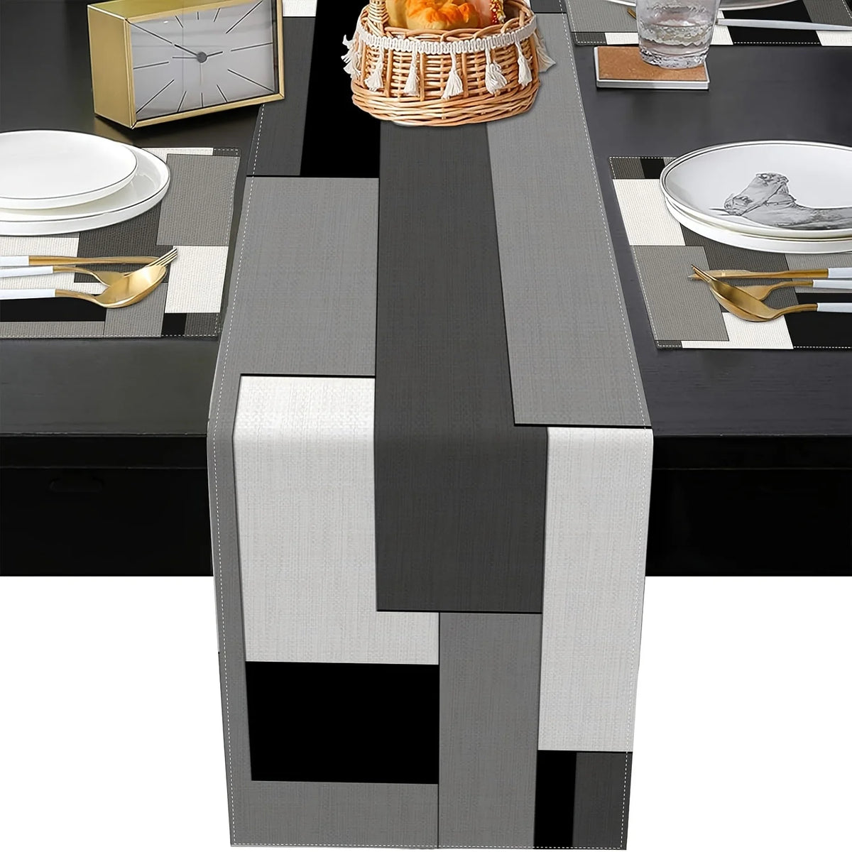 A modern geometric placemat set featuring black, gray, and silver patterns with natural wood accents on a dining table.