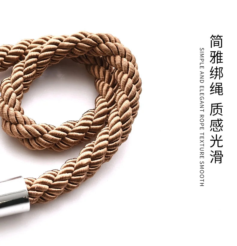A close-up of a thick, braided rope in a tan or beige color used as a curtain tieback clip.