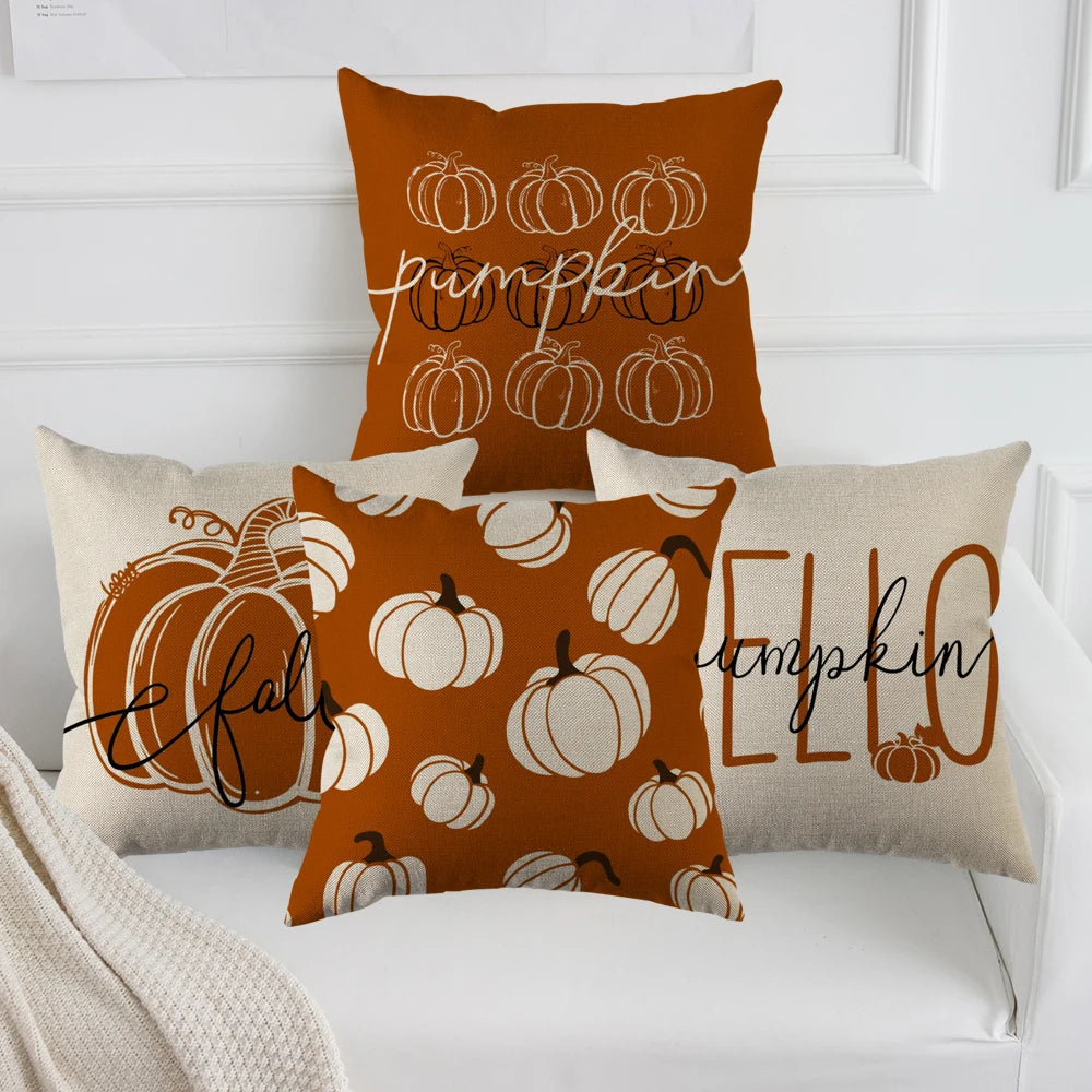 A set of orange pumpkin themed pillow covers featuring carved pumpkins and the word pumpkin