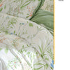 A white duvet cover set featuring a green and white leaf floral pattern on bedding.