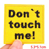 Yellow embroidered patch with black text that reads Don't touch me!