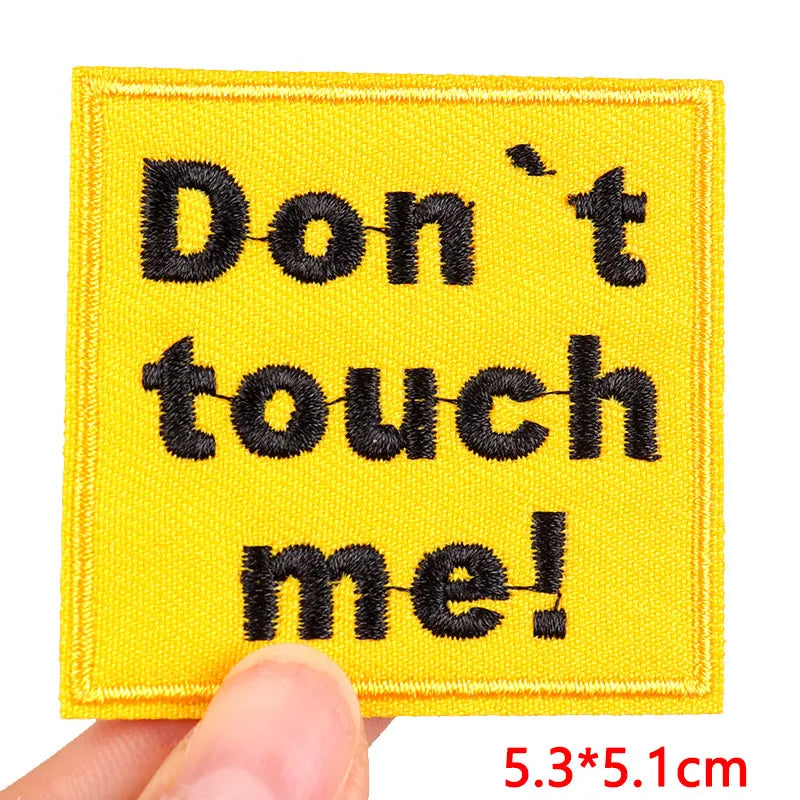 Yellow embroidered patch with black text that reads Don't touch me!