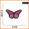 A set of five embroidered butterfly and rose iron-on patches, pink and black.