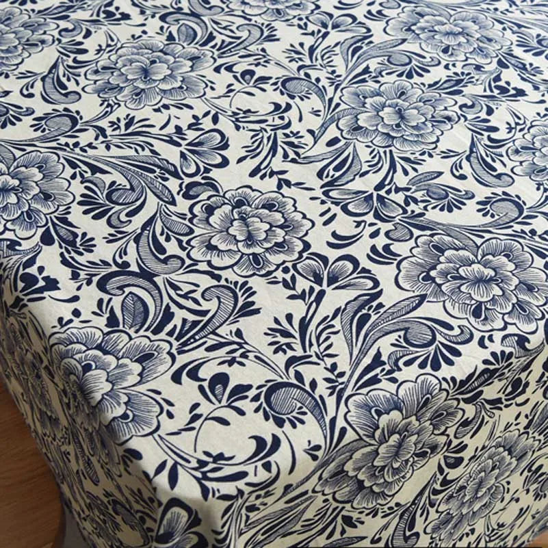 Close-up of bohemian printed linen fabric featuring blue floral and vine patterns on a white background.
