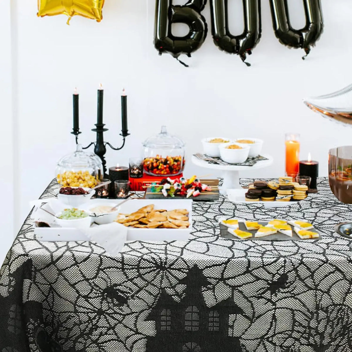 Black spider web lace table runner set for a Halloween party display