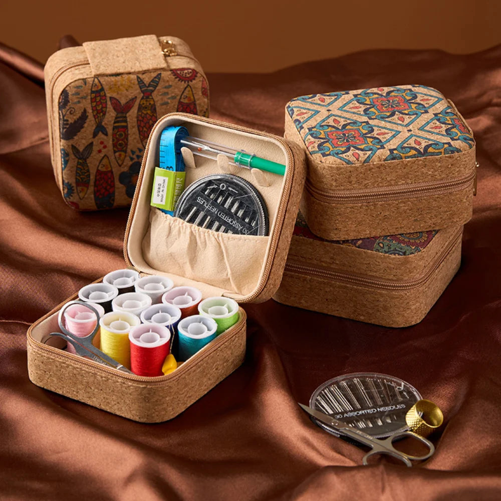 A collection of retro style zipper sewing kit storage boxes and a metal comb are displayed on brown fabric.