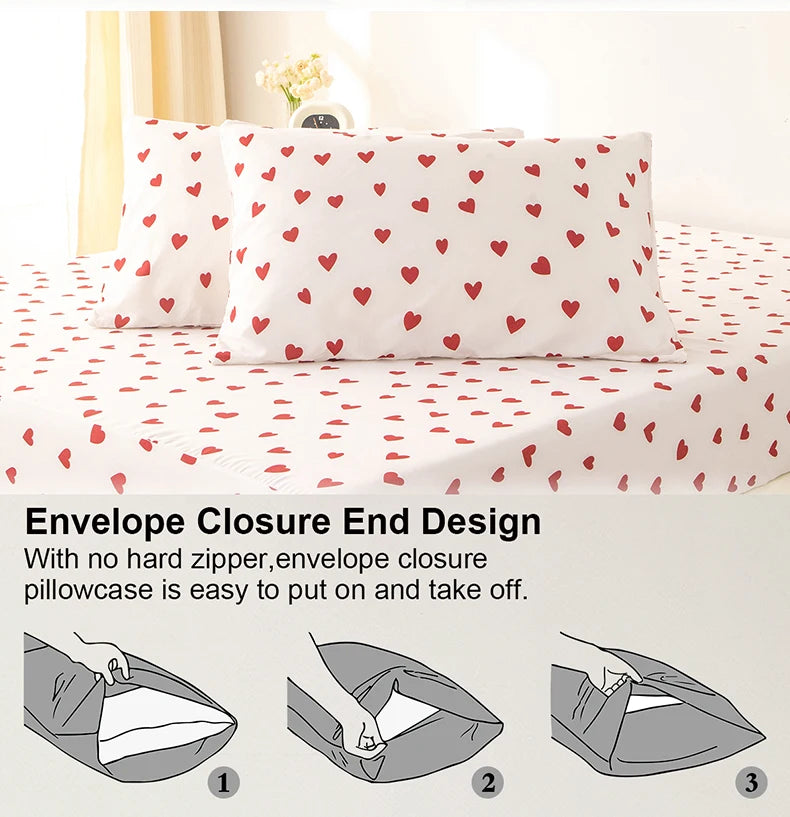 Three white pillowcases with a red heart print on a white duvet cover.