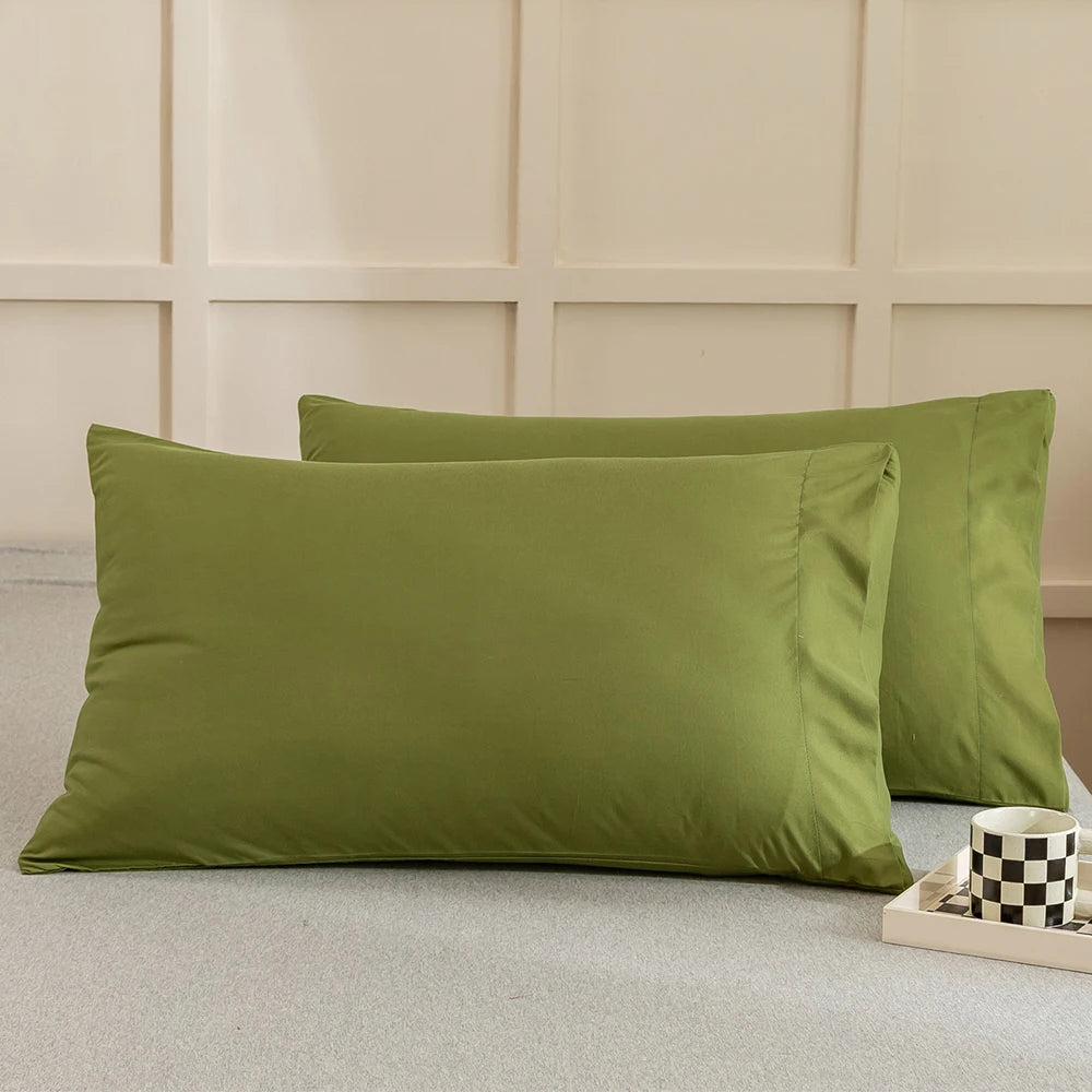 A set of solid olive green microfiber pillow covers displayed on a light gray surface.