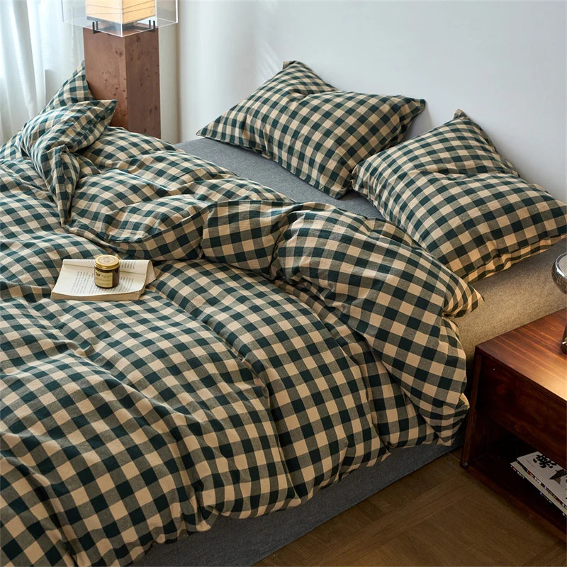A plaid duvet cover set in olive green and beige tones is displayed on a bed.