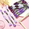 A collection of 12 pack rainbow gradient embroidery floss threads in various shades and colors laid out on a pink background.