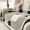 A black and white striped sofa cover featuring abstract wavy lines and a leopard print cushion.