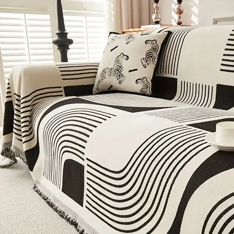 A black and white striped sofa cover featuring abstract wavy lines and a leopard print cushion.