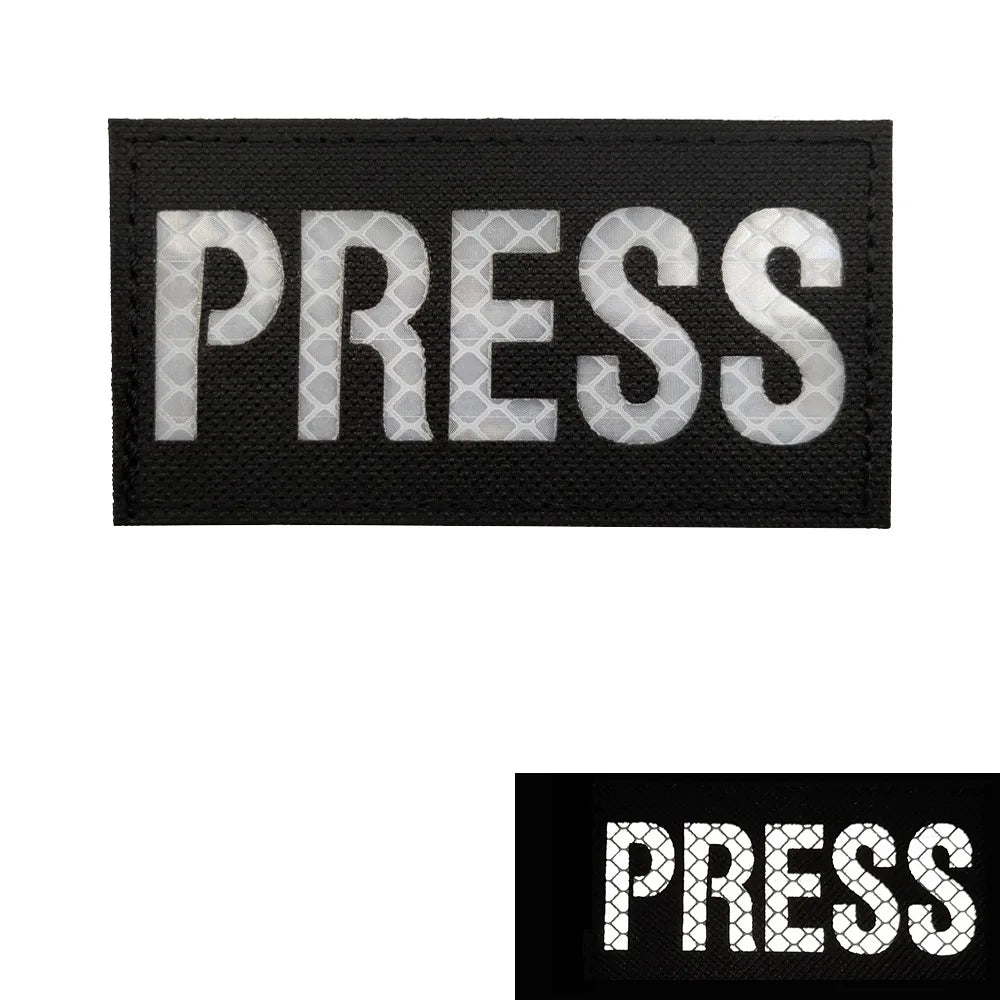 Black embroidered patch with the word PRESS in white stitching.