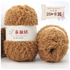 Two balls of soft brown coral velvet yarn for crafting displayed next to a bamboo comb.