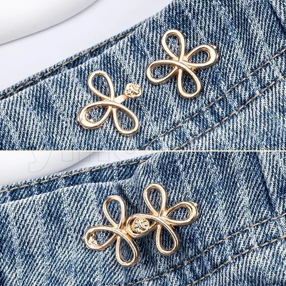 Gold-colored adjustable leaf clover waist tightener charms attached to denim fabric