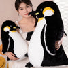 A woman is holding a large black and white penguin plush toy for kids.