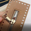 A close-up of a tan PU leather zipper frame with a gold-tone metal puller, used for handmade crochet bags.