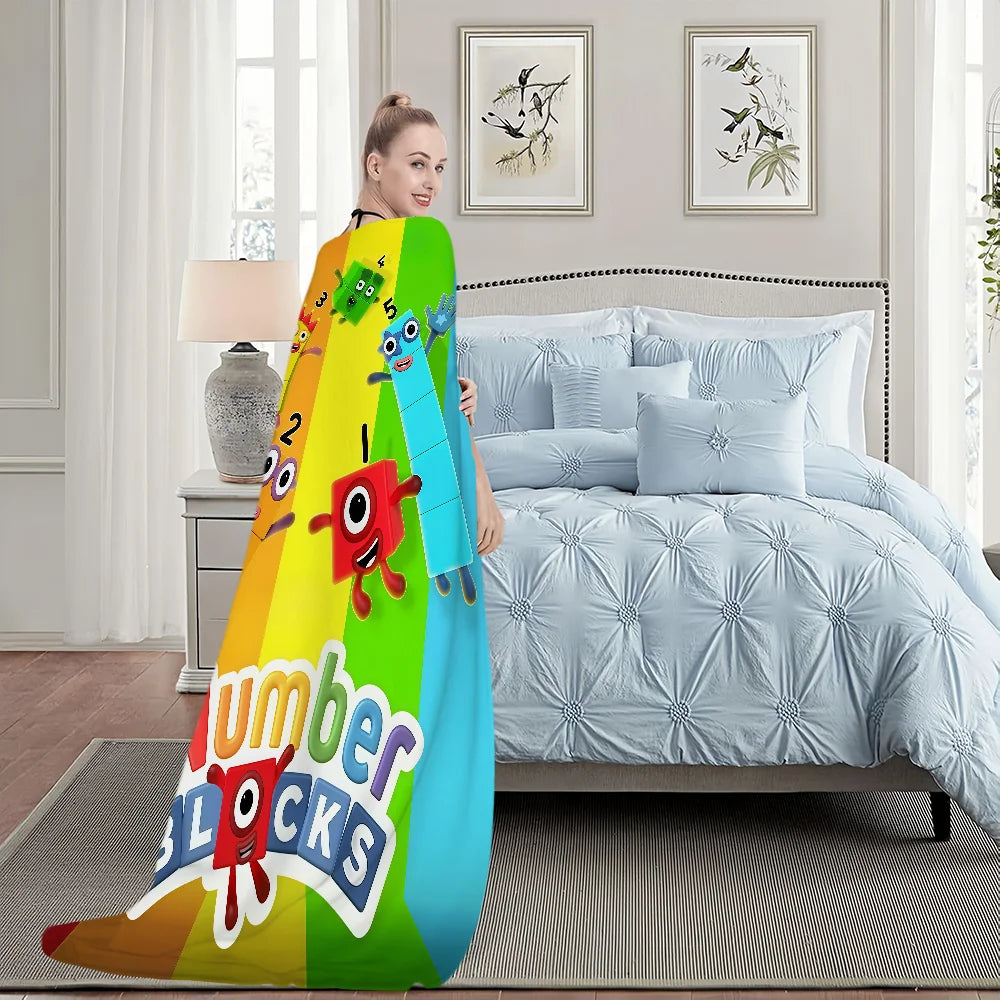 A colorful cartoon themed throw blanket featuring various animal characters and the text Number Blocks draped over a bed.
