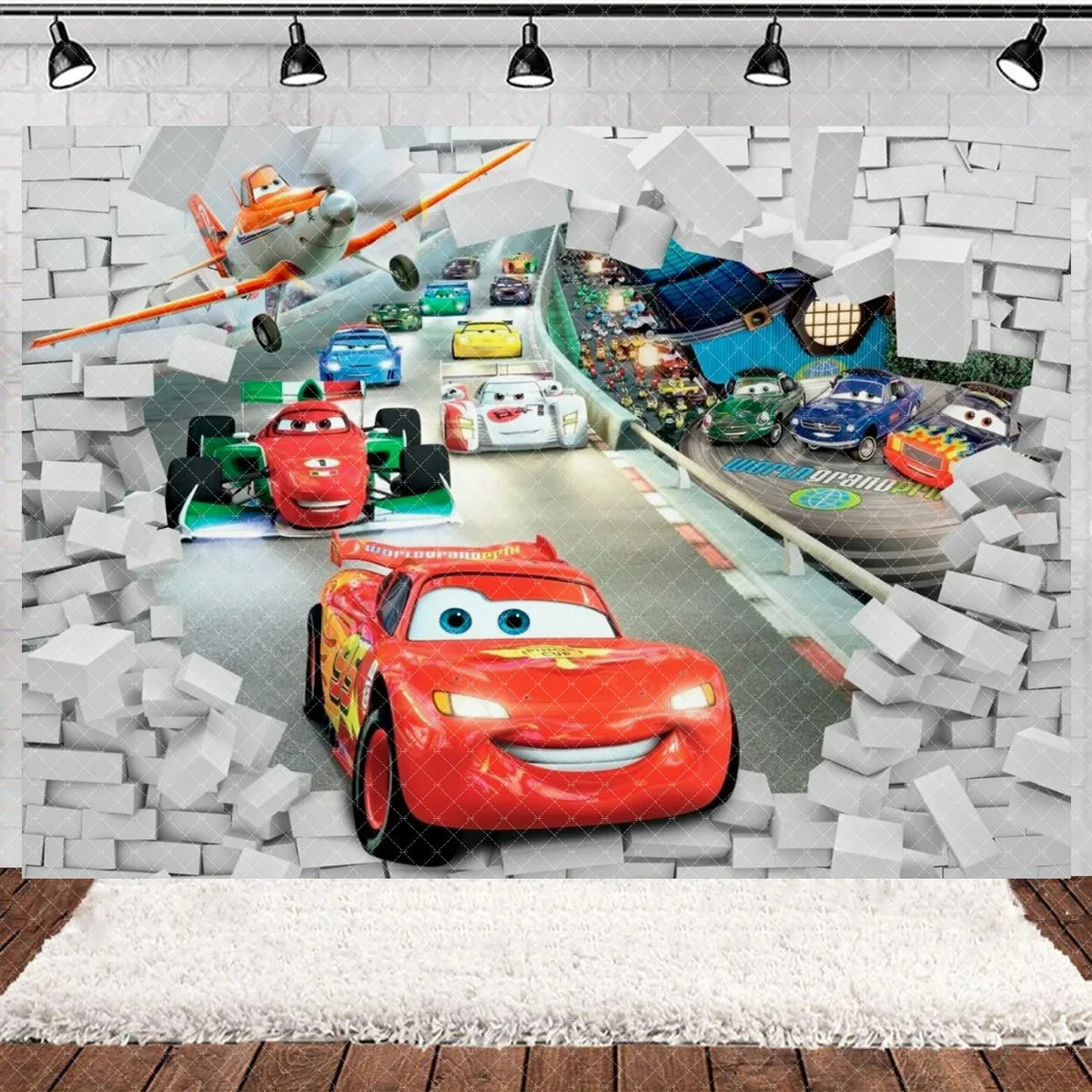A vibrant cartoon racing birthday party backdrop featuring various toy cars and a large red race car in a brick wall setting.