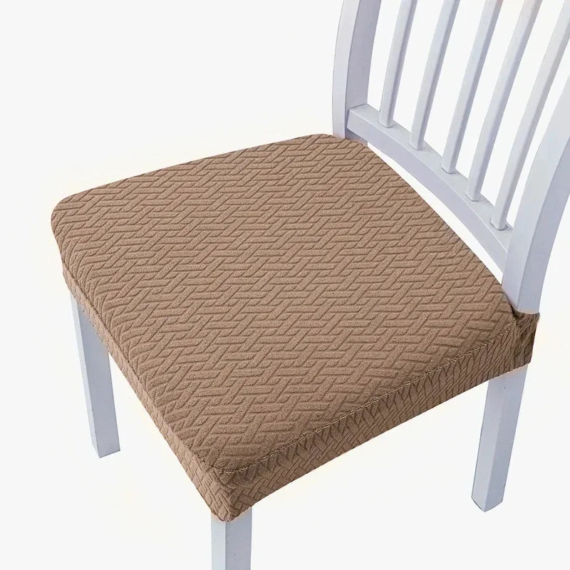 A beige quilted seat cover placed on a white wooden dining chair.