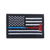 A black flag patch featuring the design of the American flag with a red hand and hook and loop backing.
