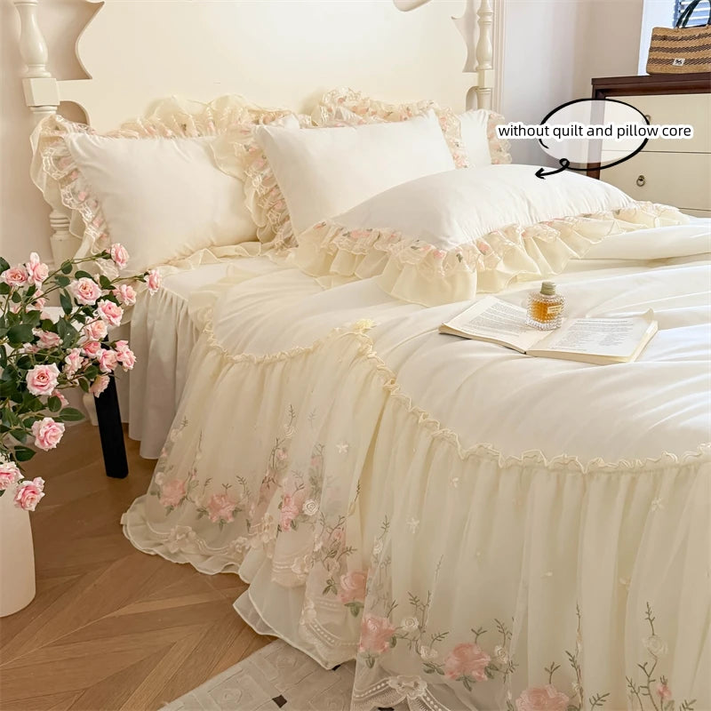 A white Korean style lace embroidered duvet set displayed on a bed with pink floral arrangements.