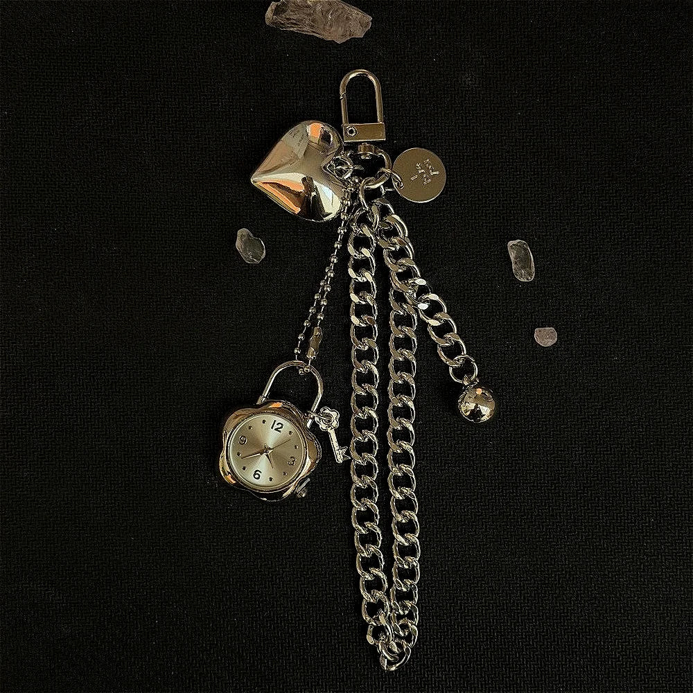 A silver star-shaped pocket watch keychain featuring a round clock face and a chain.