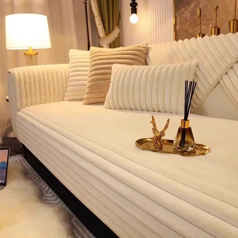 A white plush sofa seat cushion cover with vertical pleats and a gold utensil resting on the surface.