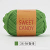 A ball of olive green hand-dyed fabric strip yarn labeled Sweet Candy with Chinese characters.