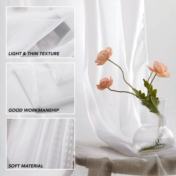 White sheer tulle window curtains draped beside a glass vase with green foliage.