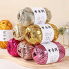 Spools of metallic fabric strip yarn in gold, pink, and silver for crochet and DIY crafts