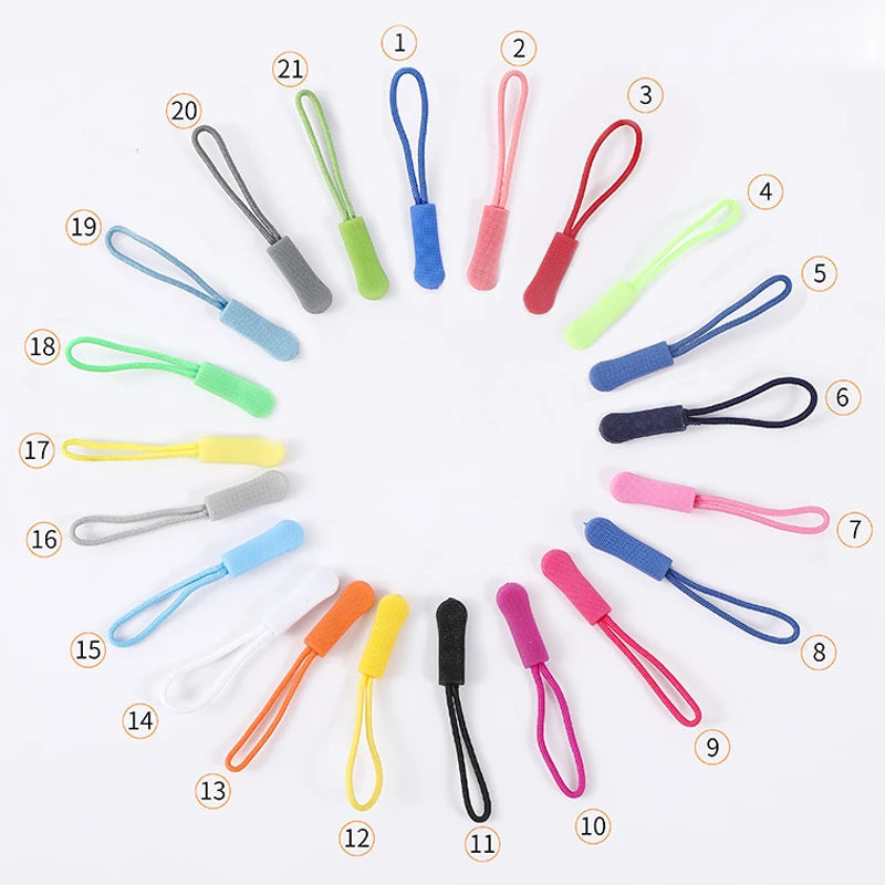 A collection of various replacement zipper pulls in different colors and shapes arranged in a circle.