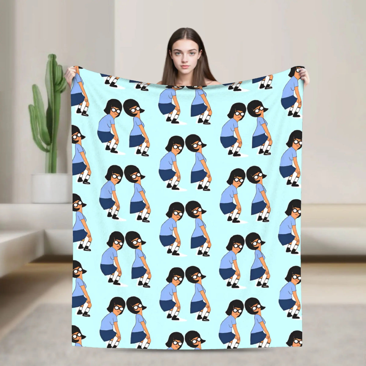 A light blue blanket featuring repeating illustrations of anime characters in various poses.