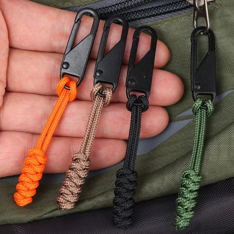 Hand holding detachable zipper pull sliders in orange, tan, black, and green colors