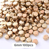 A pile of gold-colored geometric acrylic beads for jewelry making