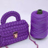Purple crochet yarn in a skein with a handbag and a gold-colored clasp